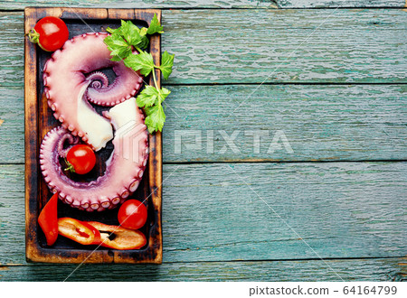 Raw octopus on cutting board Raw octopus on cutting board 64164799