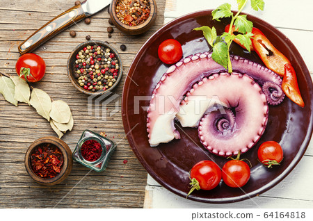 Raw octopus on wooden table Raw octopus on wooden table 64164818