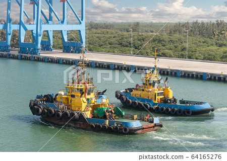 Tug boats awaiting big cargo ship in harbour for Tug boats awaiting big cargo ship in harbour for 64165276