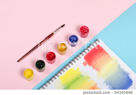 Bottles with paint and brush with colored notepad 64165696