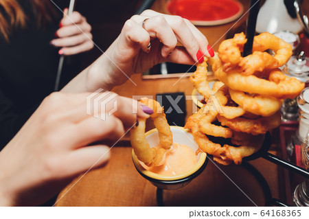 onion rings with ketchup on a dark table. onion rings with ketchup on a dark table. 64168365