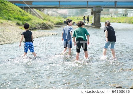 Elementary school students playing in the river 64168686