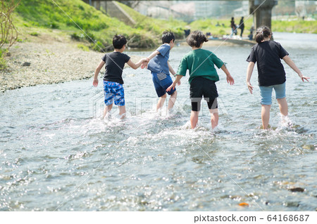 Elementary school students playing in the river Elementary school students playing in the river 64168687