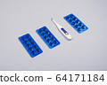 Pills and thermometer on gray table 64171184