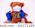 Teedy bear in face mask with doctor hands 64171189
