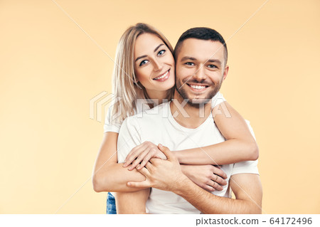 Happy smiling couple in love on beige background 64172496