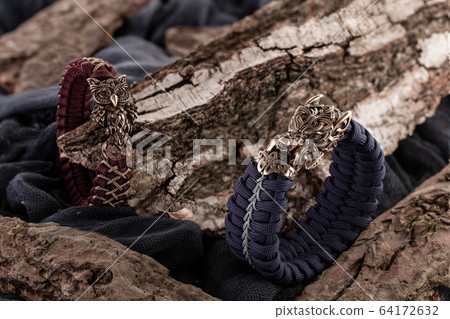 Moscow, Russia - 08/21/2019: Decoration, bracelet for men and women from the paracord on the braided bracelet made of cord Moscow, Russia - 08/21/2019: Decoration, bracelet for men and women from the paracord on the braided bracelet made of cord 64172632