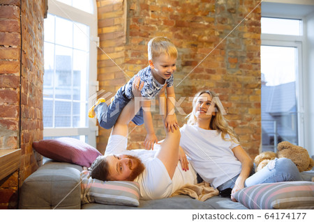 Mother, father and son at home having fun, comfort and cozy concept 64174177
