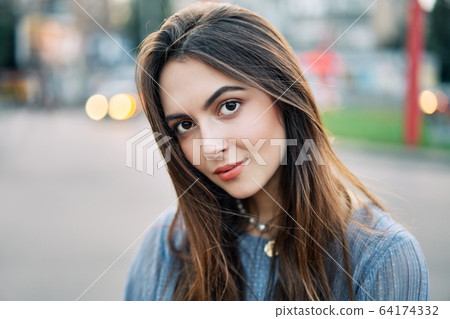 Close up young beautiful woman portrait posing in the city street Close up young beautiful woman portrait posing in the city street 64174332