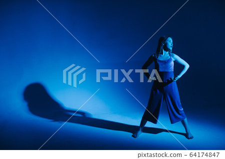 Young stylish girl dancing in the Studio on a colored neon background. Classic dancer. Young stylish girl dancing in the Studio on a colored neon background. Classic dancer. 64174847