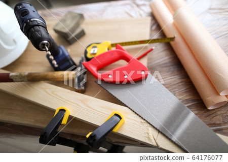 Carpenter hand tools and patterns lie on workbench 64176077