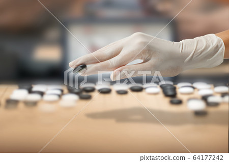 hand in rubber glove playing weiqi, baduk - salty concept hand in rubber glove playing weiqi, baduk - salty concept 64177242