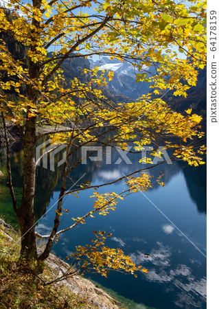 Peaceful autumn Alps mountain lake with clear Peaceful autumn Alps mountain lake with clear 64178159