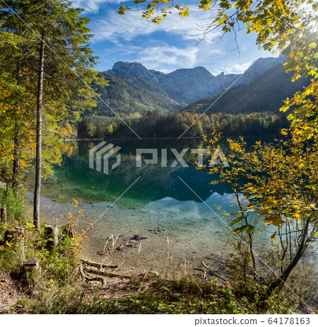 Peaceful autumn Alps mountain lake with clear 64178163