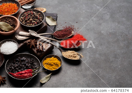 Various spices in bowls and spoons 64178374