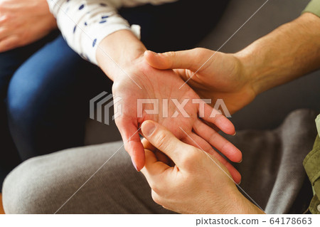 Professional palmist holding his female clients hand 64178663