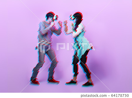 Couple with virtual reality headset are playing game and fighting. Image with glitch effect. Couple with virtual reality headset are playing game and fighting. Image with glitch effect. 64178730