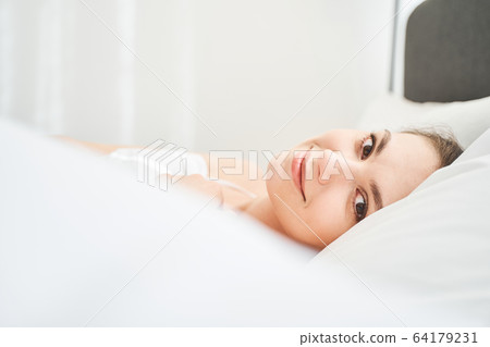 Girl in bed posing for the camera 64179231