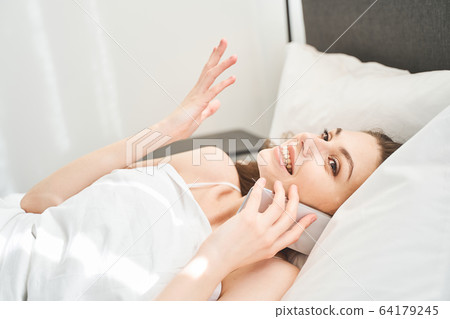 Smiling pretty girl having a phone conversation 64179245