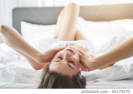 Slim attractive woman resting in a bedroom Slim attractive woman resting in a bedroom 64179270