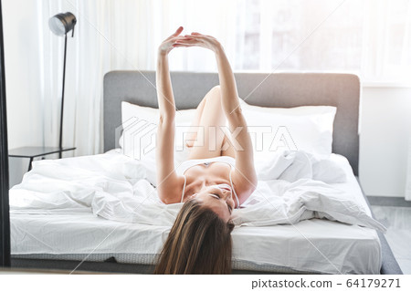 Caucasian female stretching herself in the morning 64179271
