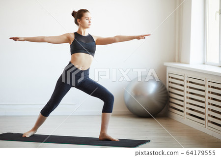 Woman exercising in health club 64179555