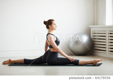 Woman sitting on the splits Woman sitting on the splits 64179556