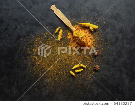 Turmeric powder and roots turmeric on black 64180257