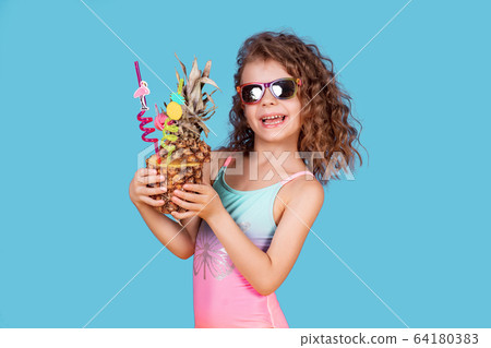 Beautiful girl in colorful swimsuit and sunglasses holding pineapple cocktail 64180383