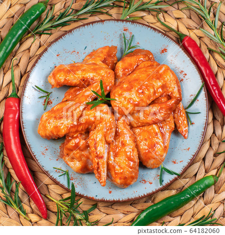 Chicken wings are raw in the marinade. Grilled chicken wings recipe.Marinated chicken wings with spices. Chicken wings are raw in the marinade. Grilled chicken wings recipe.Marinated chicken wings with spices. 64182060