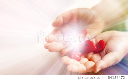 Children's hands and white background with lots of red heart motifs emitting light 64184472