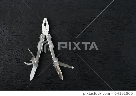 Multi-functional tool on a black textural Multi-functional tool on a black textural 64191860