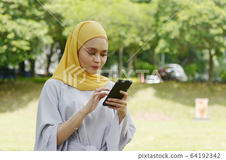 Muslim girl using smart phone 64192342