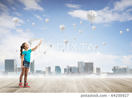 Concept of careless happy childhood with girl dreaming about something 64200927