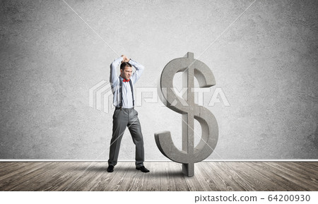 Determined banker man in empty concrete room breaking dollar figure 64200930