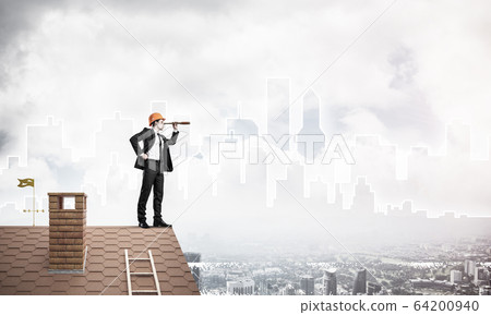 Engineer man standing on roof and looking in spyglass. Mixed med 64200940