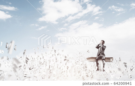 Young man floating in sky and do not want to see anything 64200941