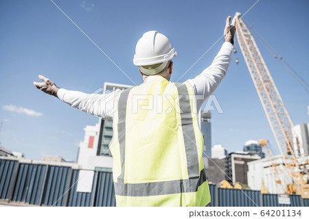 Senior foreman in glasses doing his job at building area on sunn Senior foreman in glasses doing his job at building area on sunn 64201134