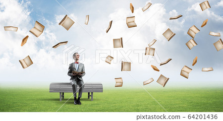 Young businessman or student studying the science and books fly around Young businessman or student studying the science and books fly around 64201436