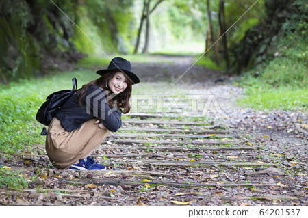 一位戴著帽子的年輕女士漫步在兵庫縣Takedao廢線的徒步旅行路線 64201537