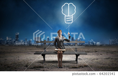Young woman with open book on bench Young woman with open book on bench 64201541