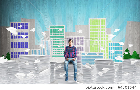 Young man sitting on pile of paper documents. 64201544