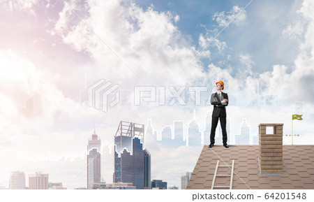 Engineer man standing on roof and looking away. Mixed media Engineer man standing on roof and looking away. Mixed media 64201548