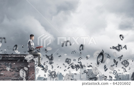 Man on roof edge reading book and symbols flying around Man on roof edge reading book and symbols flying around 64201602