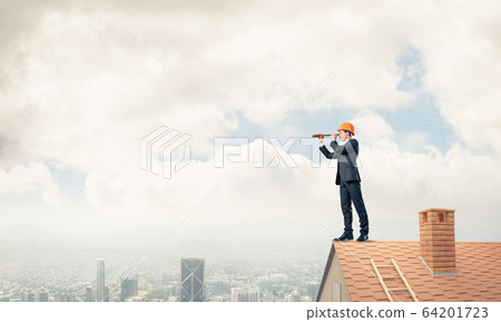 Engineer man standing on roof and looking in spyglass. Mixed med Engineer man standing on roof and looking in spyglass. Mixed med 64201723