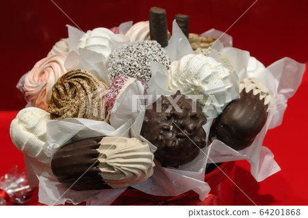 Holiday gift bouquet with sweets on red background Holiday gift bouquet with sweets on red background 64201868