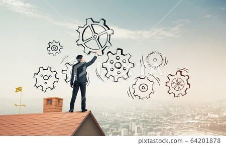 Mister boss on brick roof standing with back and draw teamwork c 64201878