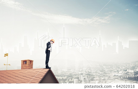 Engineer man standing on roof and looking down. Mixed media 64202018