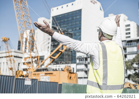 Senior foreman in glasses doing his job at building area on sunn Senior foreman in glasses doing his job at building area on sunn 64202021