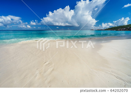 Summer vacation holiday. White clouds above blue ocean lagoon, calm waves on tropical beach Summer vacation holiday. White clouds above blue ocean lagoon, calm waves on tropical beach 64202070
